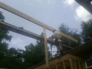 Carpenter setting a ridge beam over a new addition frame — Ice Dam Removal by Roofing Brothers in Newton Center