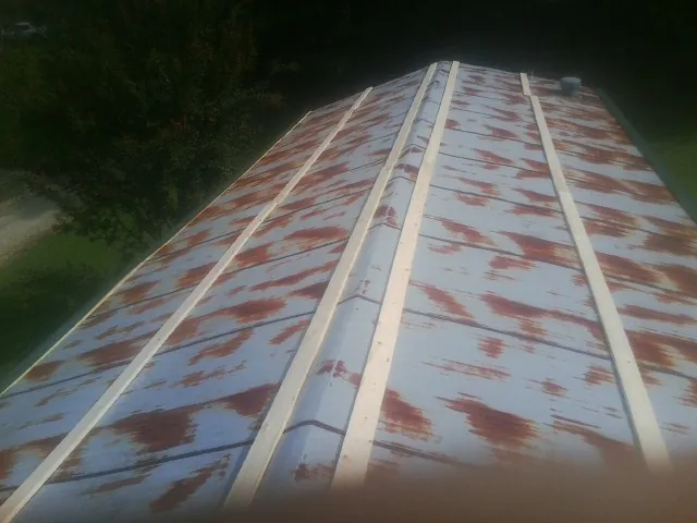 Rusted metal roof panels with new wood purlins before replacement — Storm Damage Roof Repair in Newton Center by Roofing Brothers
