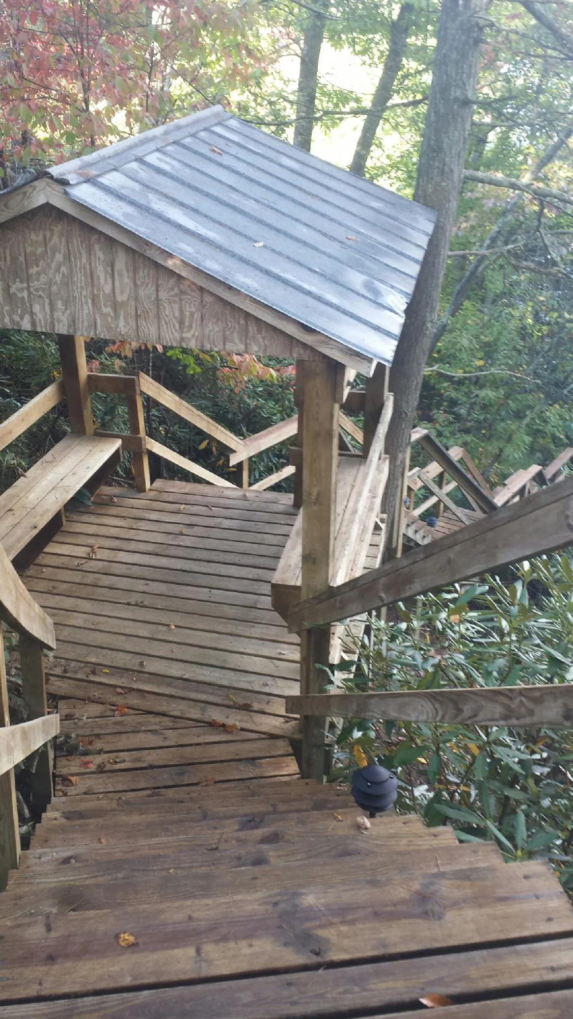 Metal roofed shelter over wooden steps on a wooded walkway — Skylight Repair & Installation work by our crew in Newton Center