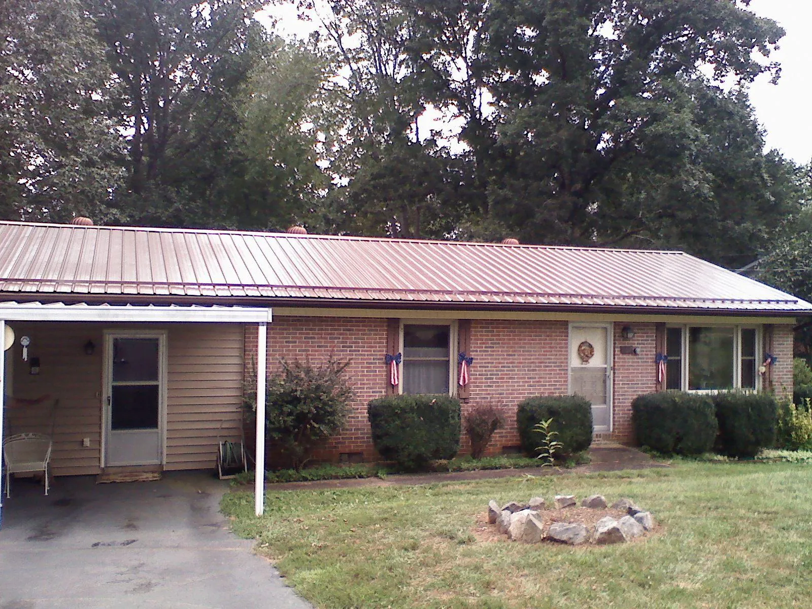 Bronze metal roof and carport on a brick ranch home — Roof Repair work by our crew in Newton Center
